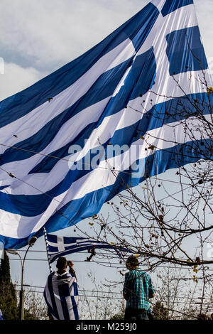 Protesters take pictures of the giant Greek flag waving above the crowd. Greeks gather massively in Syntagma Square to demonstrate against the use of the name 'Macedonia' by FYROM. The final name of the former Yugoslav state is decisive about its entering in NATO.   Photo: Cronos/Kostas Pikoulas Stock Photo