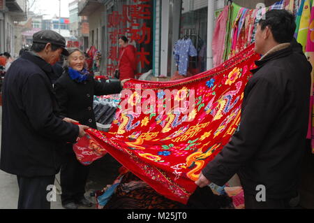 (180206) -- BEIJING, Feb. 6, 2018 (Xinhua) -- File photo taken on Jan. 4, 2009 shows villagers choosing beddings in Zhuangmu Town of Changfeng County, east China's Anhui Province. New Year goods, an indispensable part for Chinese during the Spring Festival, is believed to be the carrier for luck and fortune in a brand new year. It's not the goods but the process that people prepare the goods with their beloved ones that matters the most. Spring Festival, or better known as Chinese Lunar New Year, is the most important festival for all Chinese, which has a history of more than 4,000 years. It Stock Photo