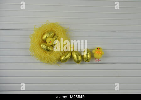Easter time decorations with a nest of golden chocolate Easter eggs Stock Photo