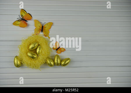 Easter time decorations with a nest of golden chocolate Easter eggs Stock Photo