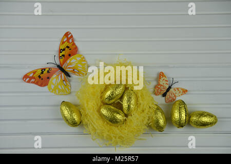Easter time decorations with a nest of golden chocolate Easter eggs Stock Photo