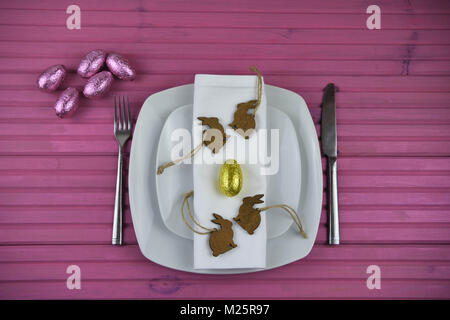 Easter time table place setting with chocolate Easter eggs and decorations Stock Photo