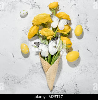 Daffodil flowers in the waffle cone with easter eggs,vintage background Stock Photo
