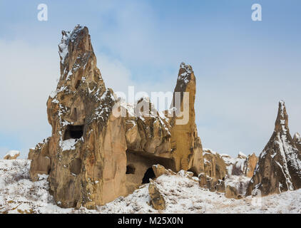 View of ancient Uchisar cave town and a castle of Uchisar dug from a mountains in Cappadocia, Central Anatolia,Turkey. Winter time with sun Stock Photo