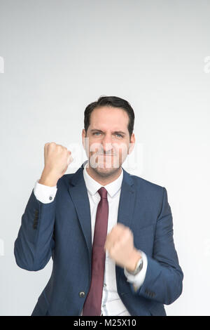 Excited well dressed man punches the air looking happy and excited- isolated on a white background. He is fair skinned with a smart hairstyle Stock Photo