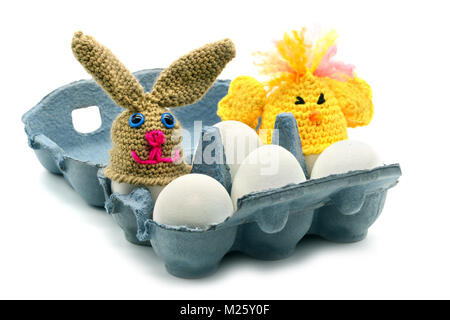 easter Eggs box with crochet egg cup tops in chicken und easter bunny look. white isolated background Stock Photo