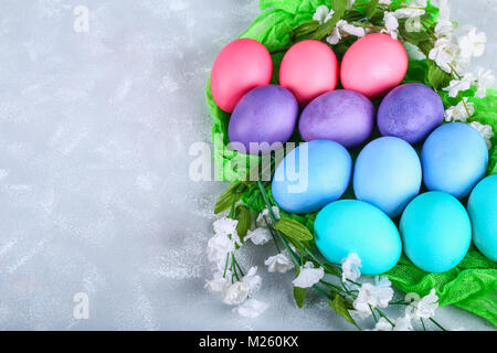 Colored Easter eggs with white flowers on a gray concrete background Stock Photo