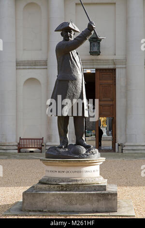 Statue of a Chelsea Pensioner outside of the Royal Hospital Chelsea in London, England. The bronze statue is depicted with a tricorn hat and cane. Stock Photo