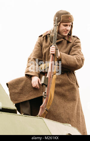 Gomel, Belarus - November 26, 2016: The Soviet soldier with an automatic SVT rifle, in a Overcoat and caps with a fur hat, is standing on the roof of  Stock Photo