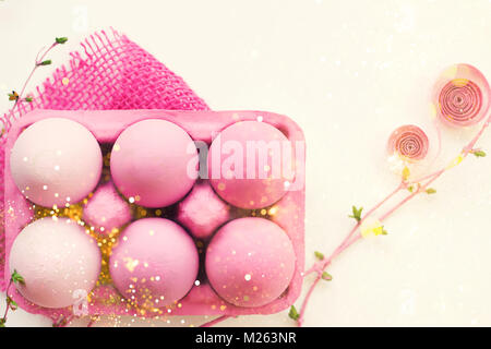 Pink colored easter eggs in pink box, with pink decoration, on white background; with glitter and copy space; easter eggs background Stock Photo
