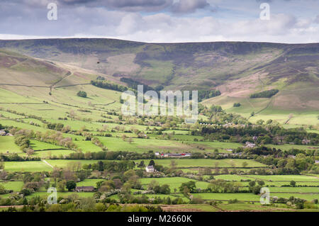 The moorland plateau of Kinder Scout rises above the lush pasture fields of Edale valley in Derbyshire, in England's Peak District National Park. Stock Photo