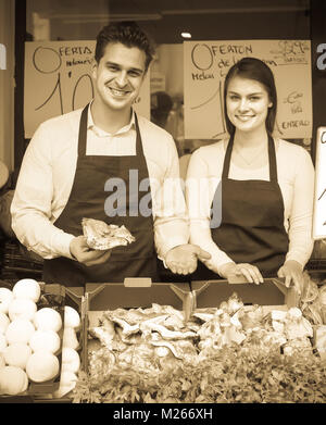 european salespeople with farm mushrooms in market, prices are on Spanish Stock Photo