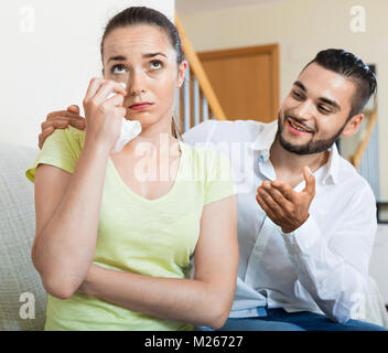 Young smiling  man talking to upset woman Stock Photo