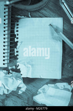 Crumpled empty pages and notebook lying on wooden surface Stock Photo