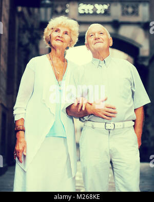 Smiling loving mature spouses enjoying walk around European city Stock Photo