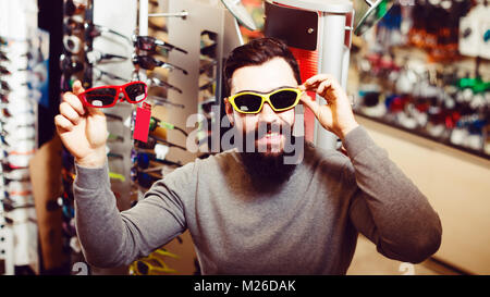 Young man trying on sunglasses in a sporting goods store Stock Photo