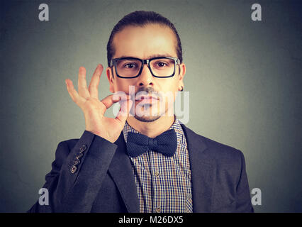 Confident serious man zipping mouth keeping confidential information while looking at camera. Stock Photo