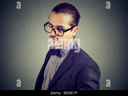 Young man in suit and eyeglasses looking skeptically at camera. Stock Photo