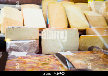 Cheese collection on counter of grocery shop Stock Photo