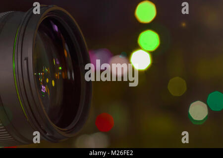 glass lens on the background. photo lens with blurred flares of street lights at night bokeh. concept. toning Stock Photo