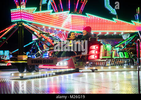 Two young women girls sharing a ride on the twister ar Aberystwyth fairground Wales UK, November 2017 Stock Photo