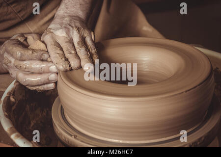 elderly man making pot using pottery wheel in studio Stock Photo