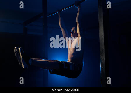 Man doing exercises for the muscles of the hands on the crossbar Stock Photo
