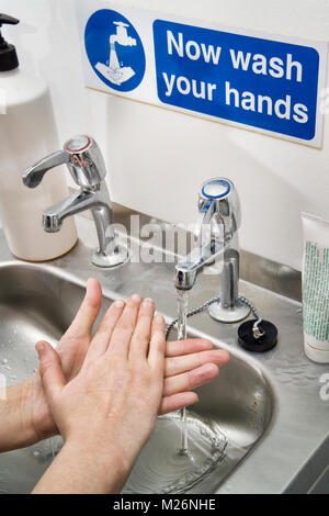 Hand-washing at an industrial basin in a biosciences laboratory, using techniques recommended by medical & hygiene experts for use in clinical situati Stock Photo