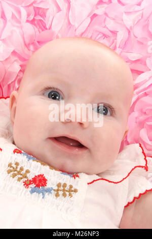 beautiful 3 month old baby girl happy playing in cot Stock Photo