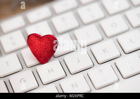 Small red heart on keyboard internet dating concept, Valentine Day Stock Photo
