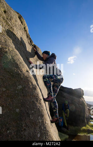Female climber, Burbage Edge, Peak District, Derbyshire, Sheffield, England, UK Female climber, Burbage Edge, Peak District, Derbyshire, Sheffield, England, UK