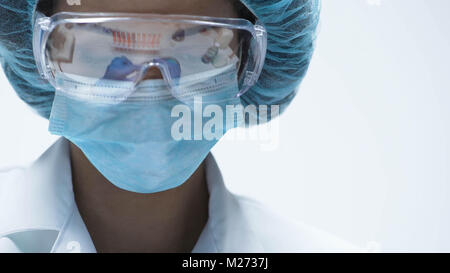 Mixed-race chemist working in security goggles, conducting experiment, close-up Stock Photo