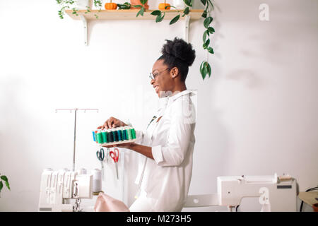 african seamstress holding coils with threads Stock Photo