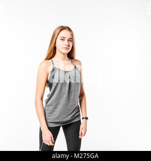 Young confident teenage fitness girl standing against white background Stock Photo