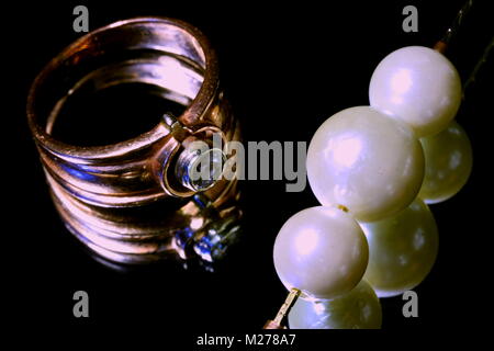 Gold ring and pearls on black mirror Stock Photo