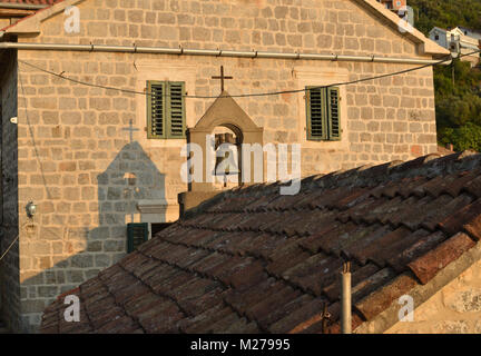 Belfry pf a small old church with a shadow of it on a near-by coastal palace Stock Photo