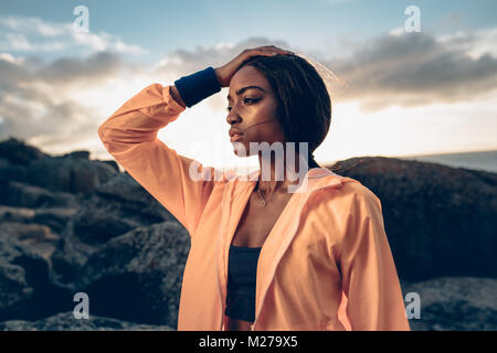 Tired young woman relaxing after exhaustive exercise. fitness female feeling exhausted after workout. Stock Photo
