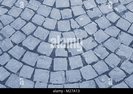 blue cobblestone road. a stone road in the city. stone road surface. bacjground, texture. toned Stock Photo