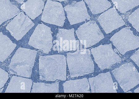 blue cobblestone road. a stone road in the city. stone road surface. bacjground, texture. toned Stock Photo
