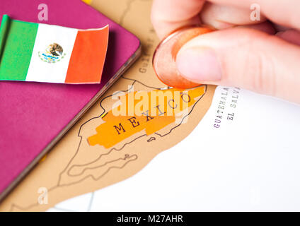 Travel holiday to Mexico concept with passport and flag with female hand choosing Mexico on the map Stock Photo