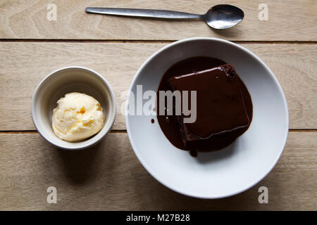 Chocolate brownie served with a warm sauce and vanilla ice cream. The dish is a popular British pub meal. Stock Photo