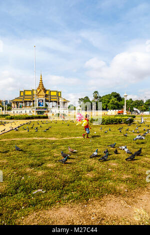 Local Cambodian child selling balloons by the Royal Palace and Silver Pagoda in Royal Palace Park, Phnom Penh, capital city of Cambodia, SE Asia Stock Photo