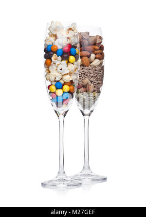 Popcorn and candies glass with healthy nuts glass on white background Stock Photo