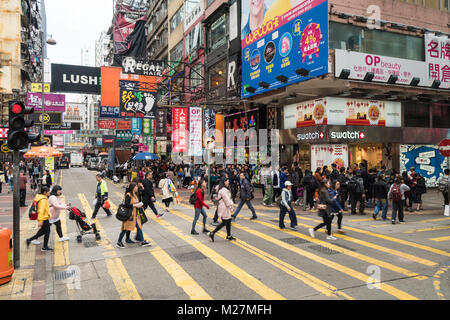 Hong Kong - January 25 2018: People crossing a busy street in the very crowded Mong Kok shopping district in Kowloon, Hong Kong Stock Photo