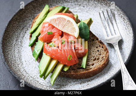 Sandwich with smoked salmon and avocado on plate. Selective focus Stock Photo