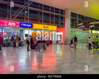 Car rental booths in the arrivals hall at Alicante Airport at night. Alicante, Spain. Stock Photo