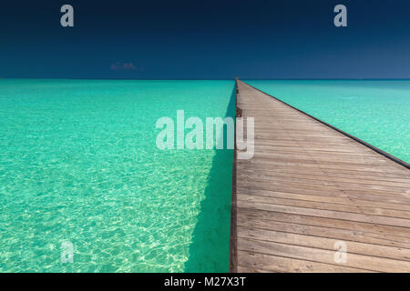 Wooden long jetty over lagoon in Maldives with amazing clean water ...