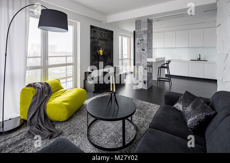 Black and white modern living room with green sack chair