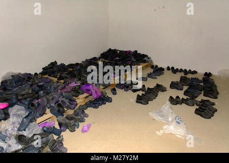 Waste production. Old abandoned rubber multi-colored slippers in the ruined building. The structure of the times of the USSR. Ruin and vandalism. Stock Photo