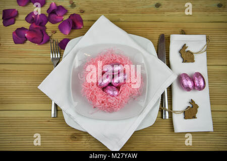 Easter time table place setting with decorations of a nest and chocolate Easter eggs Stock Photo
